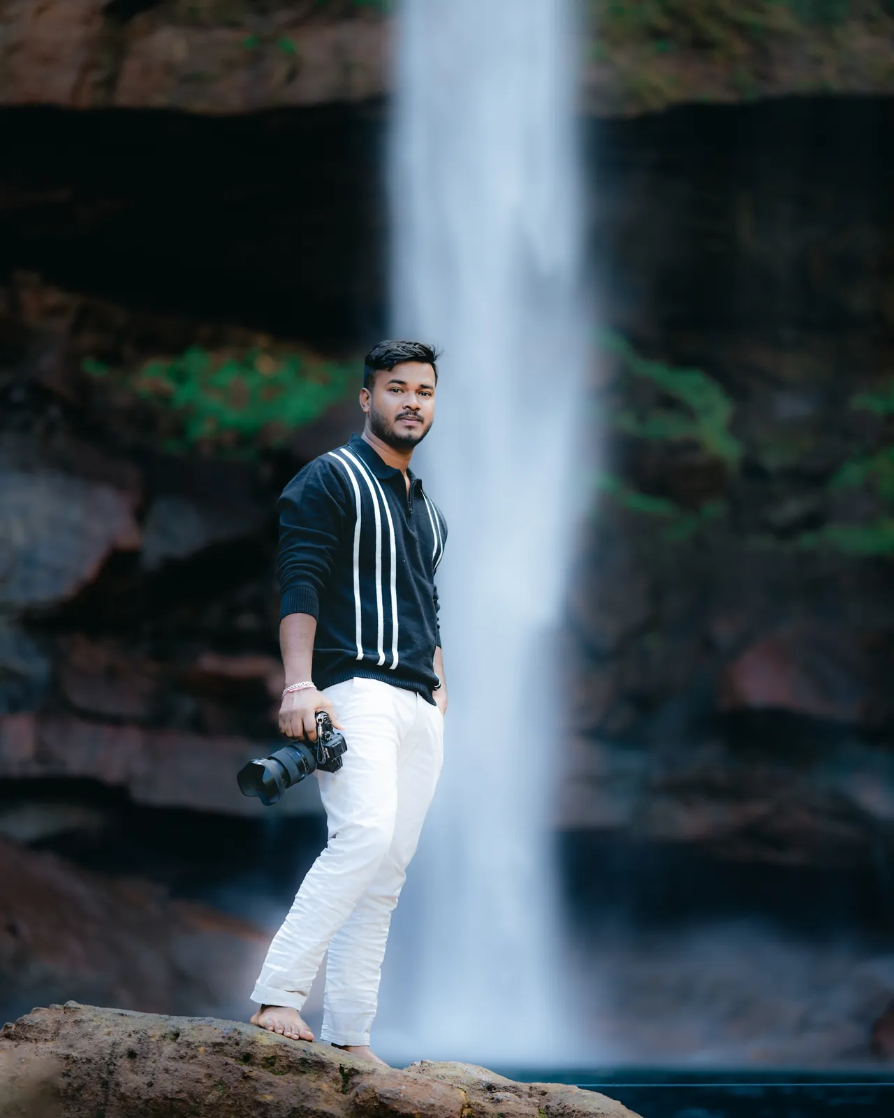 Lav Ghosh with his camera beside a waterfall